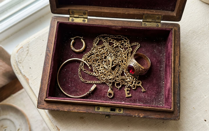 Open jewelry box with old gold chains and rings